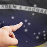 Mão apontando para Bandeira do Brasil