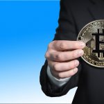 Mão segurando Bitcoin em duas mãos