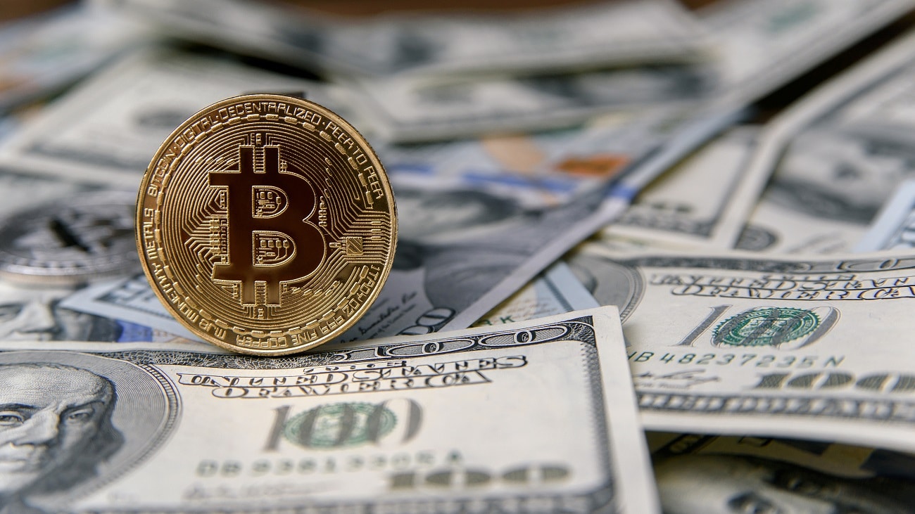 Moeda digital Bitcoin em cima de pilha de dólares