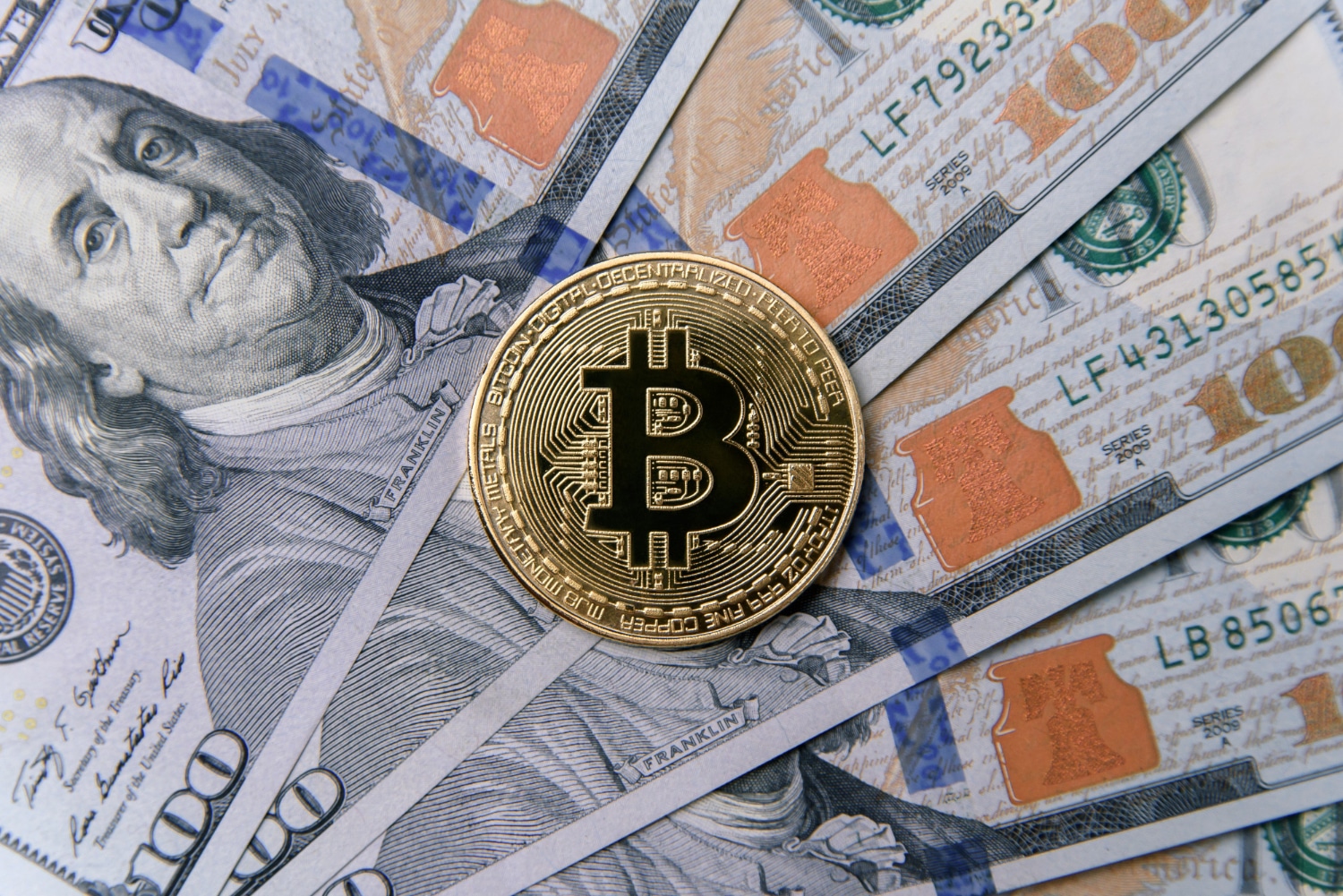 Criptomoeda Bitcoin sobre notas de Dólar dos Estados Unidos