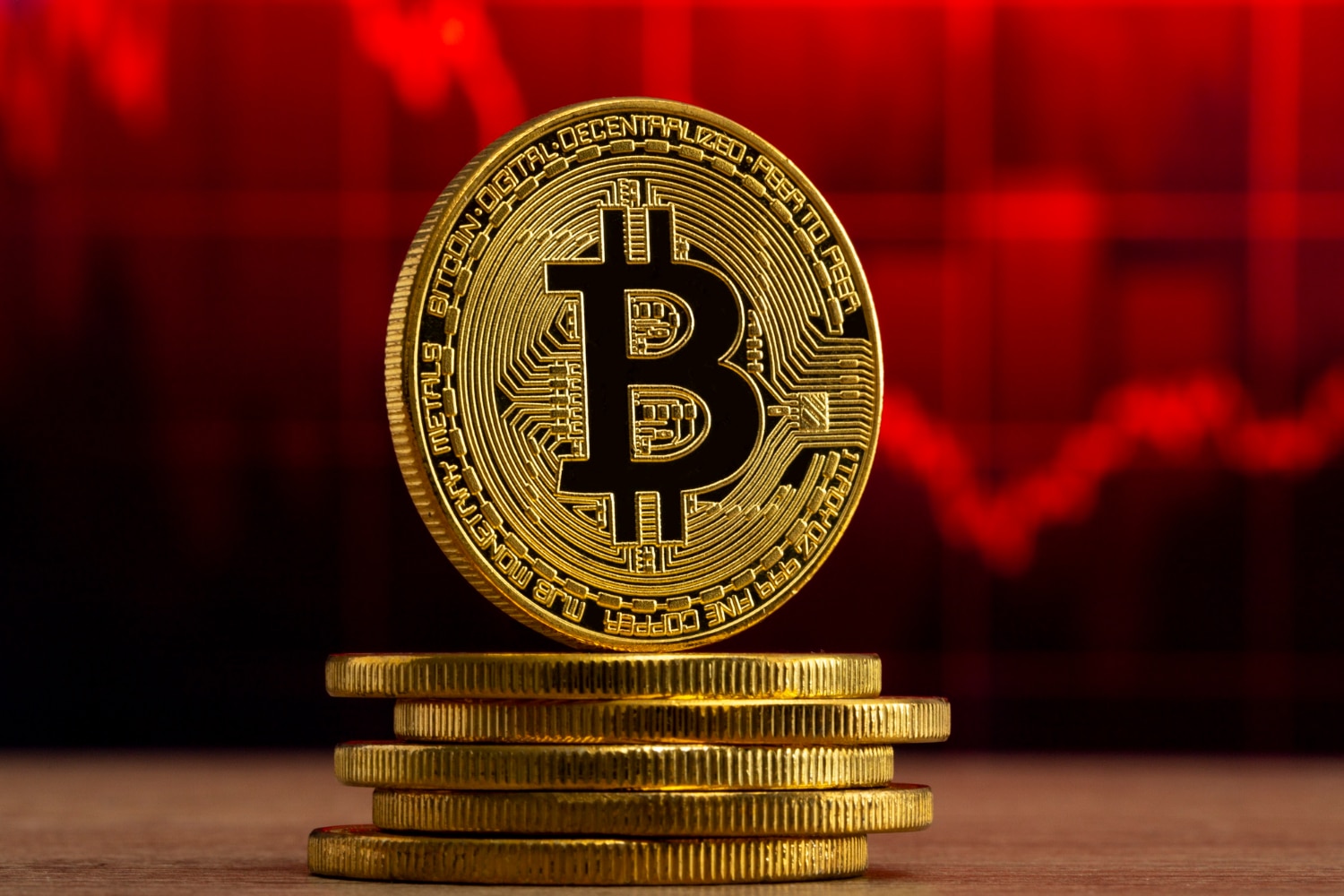 Moeda Bitcoin em frente a um gráfico vermelho