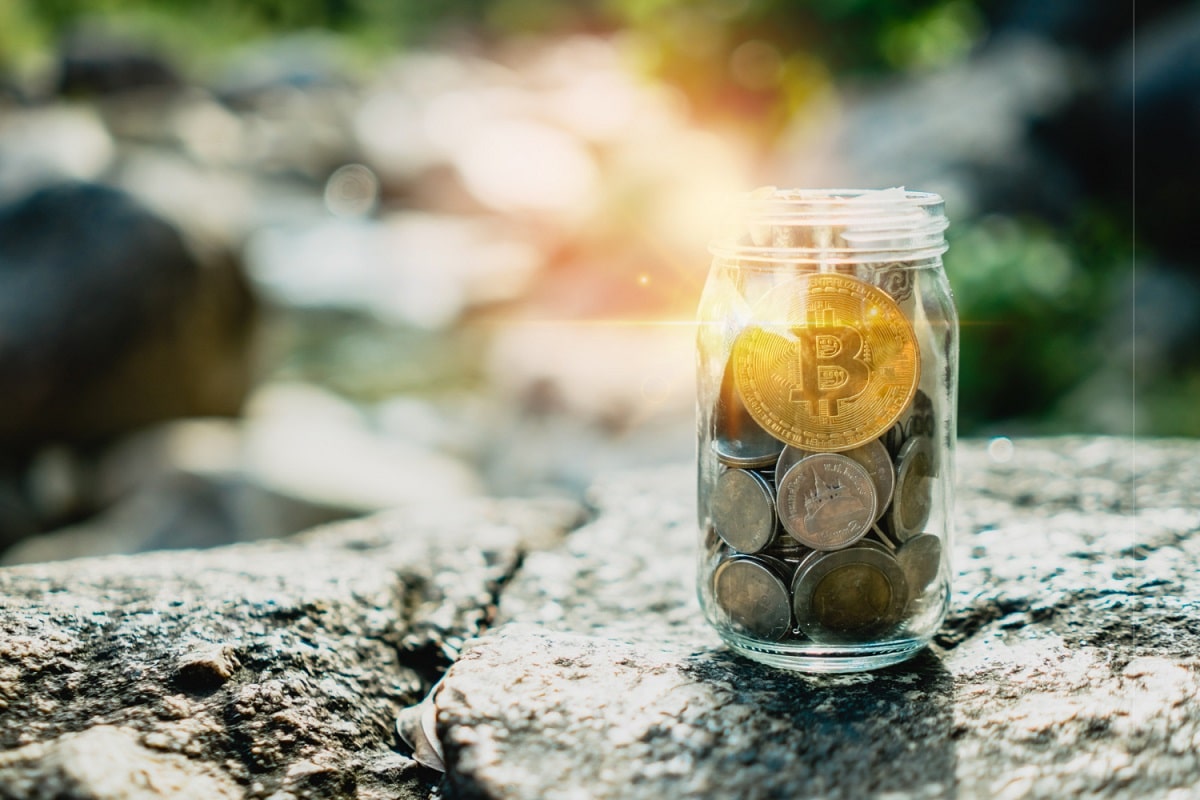 Bitcoin em cima de outras moedas em um pote