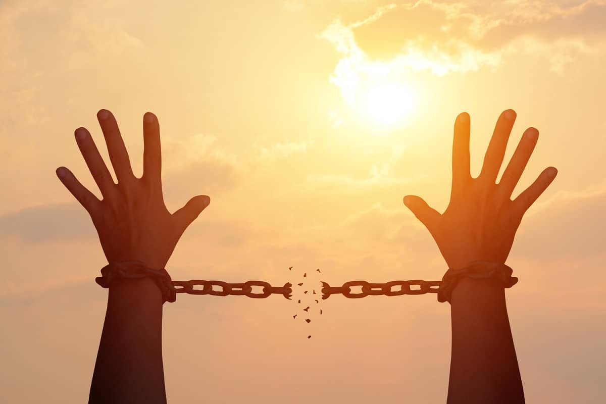 Mãos se libertando das correntes rumo a liberdade
