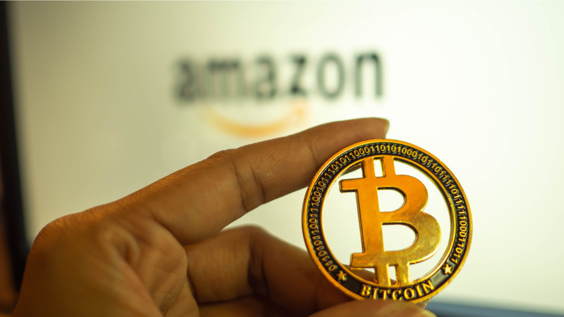 Amazon e mão segurando Bitcoin