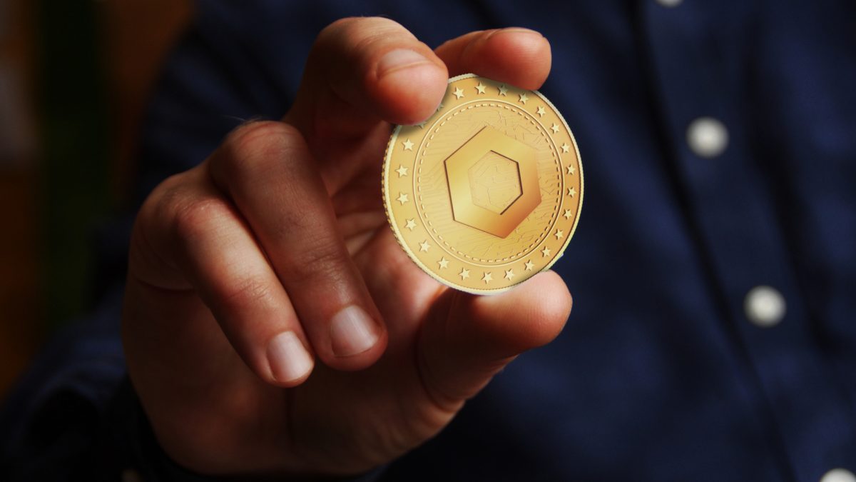 Homem segurando criptomoeda Chainlink LINK