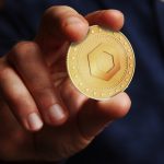 Homem segurando criptomoeda Chainlink LINK