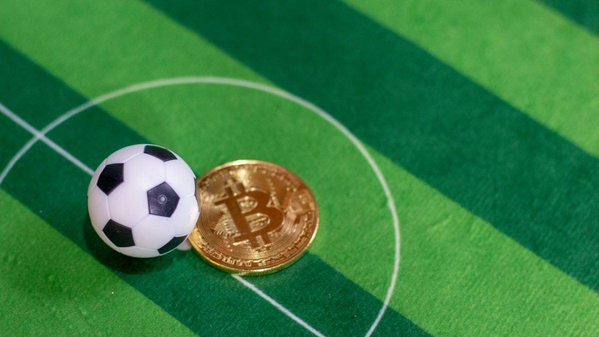 Bola de Futebol em campo e Bitcoin criptomoedas