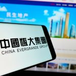 China Evergrande Group em tela de celular e computador Tether Bitcoin criptomoedas colapso crise
