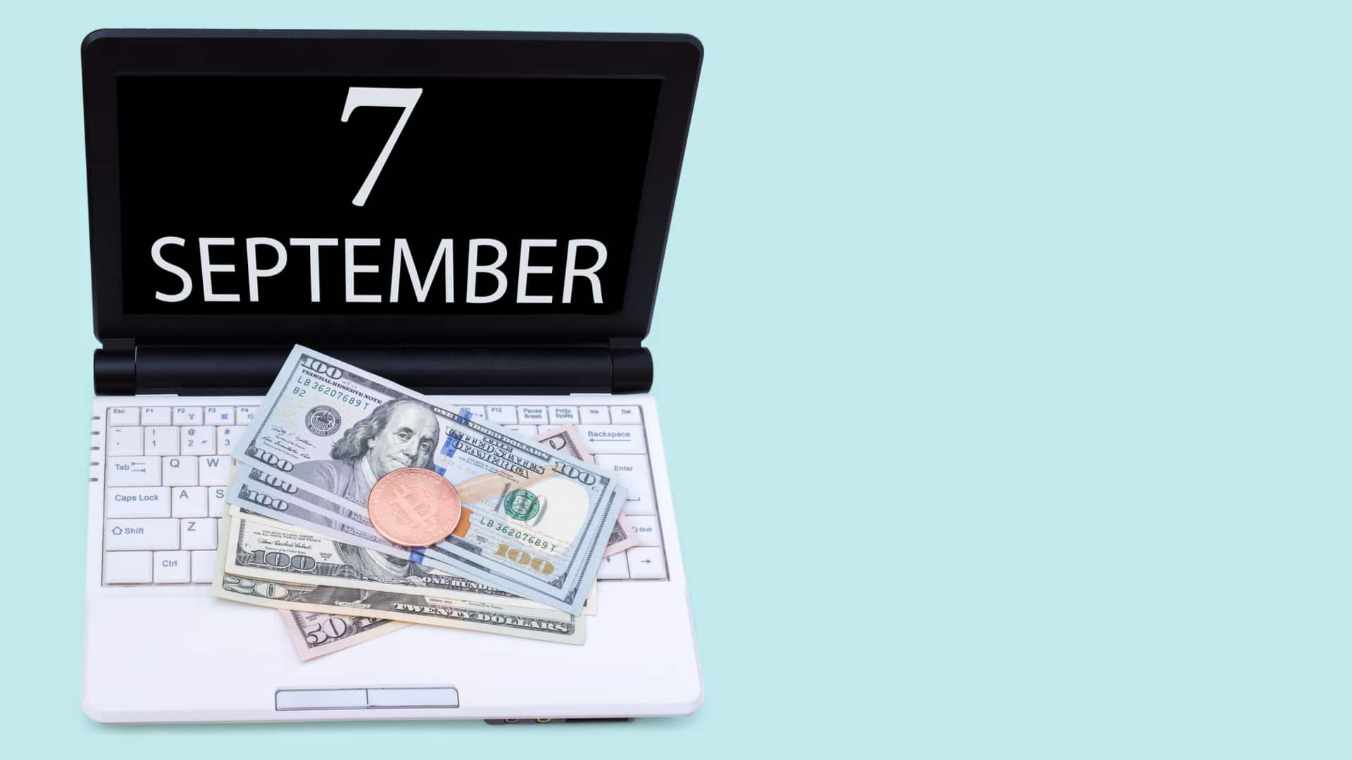 Notebook com a data de sete de setembro com Bitcoin e dólar em cima comprar