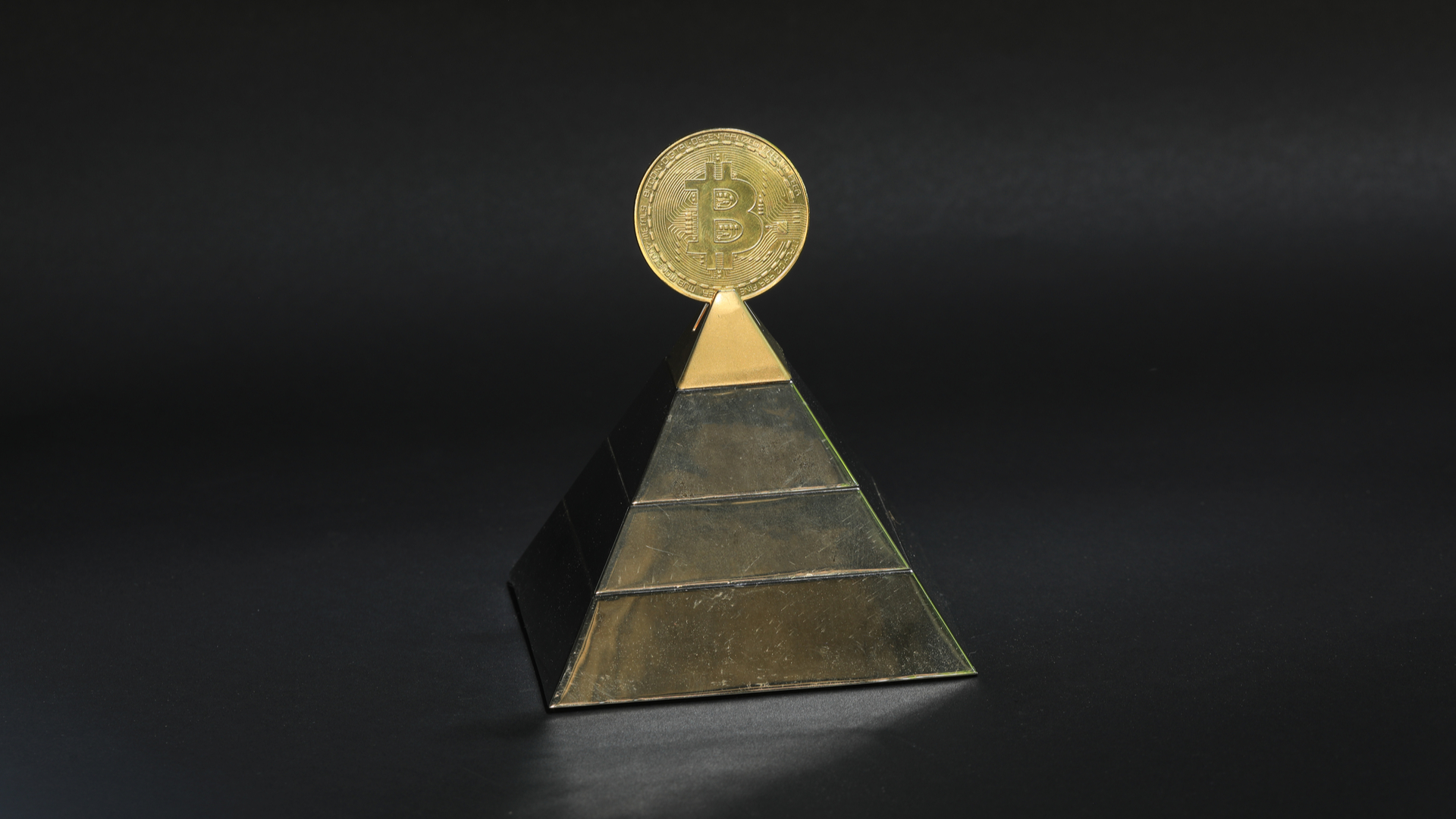 Pirâmide com símbolo do Bitcoin em cima