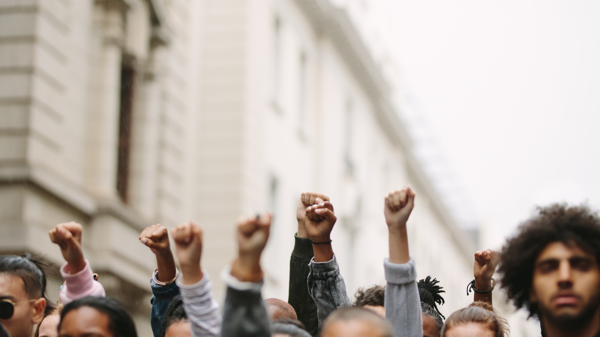 Punhos de grupo de manifestantes erguidos no ar