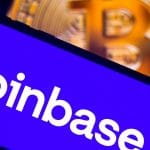 App da Coinbase e Bitcoin ao fundo