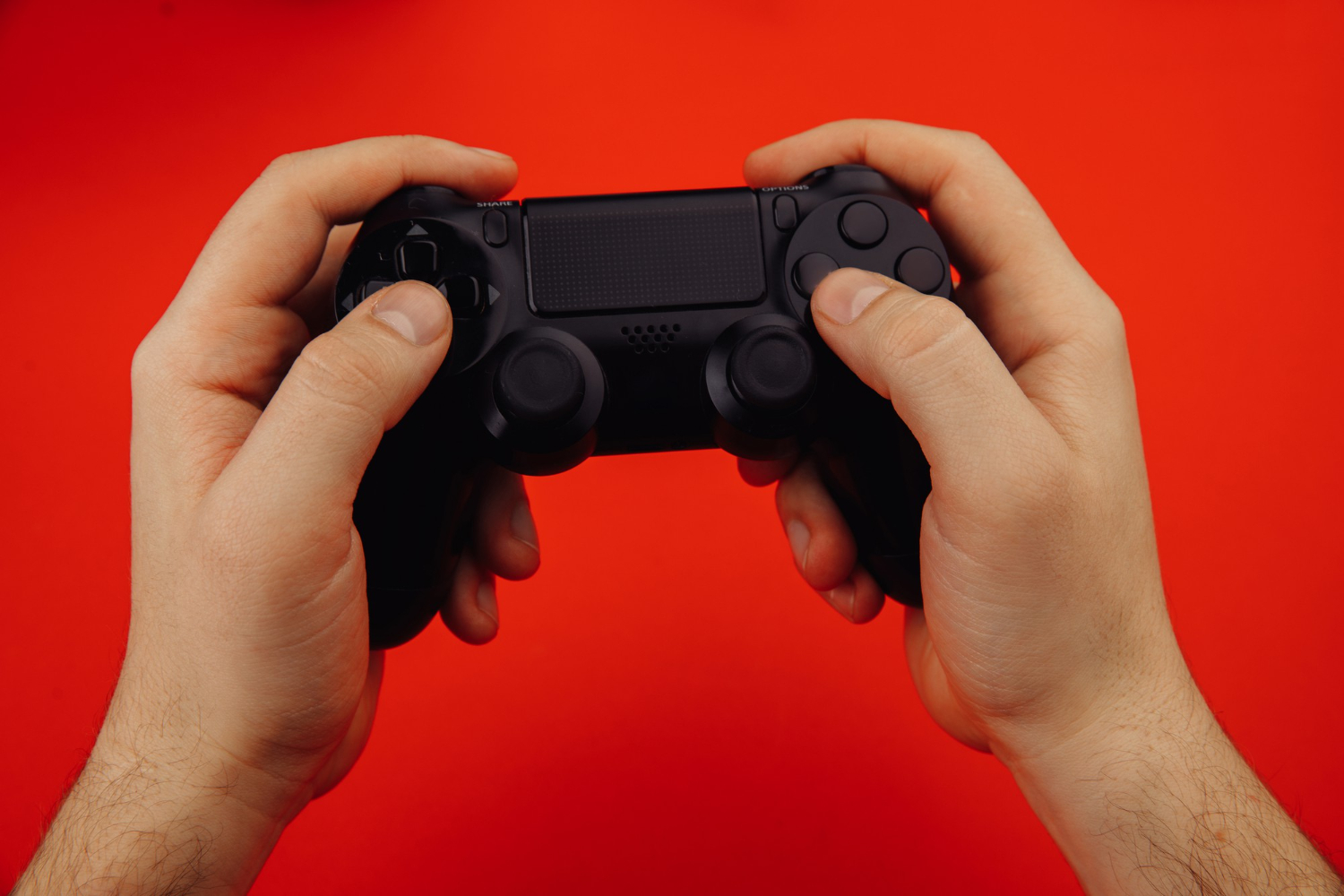 Controle de PlayStation na mão de jogador