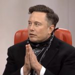 Elon Musk com mãos juntas em conversa