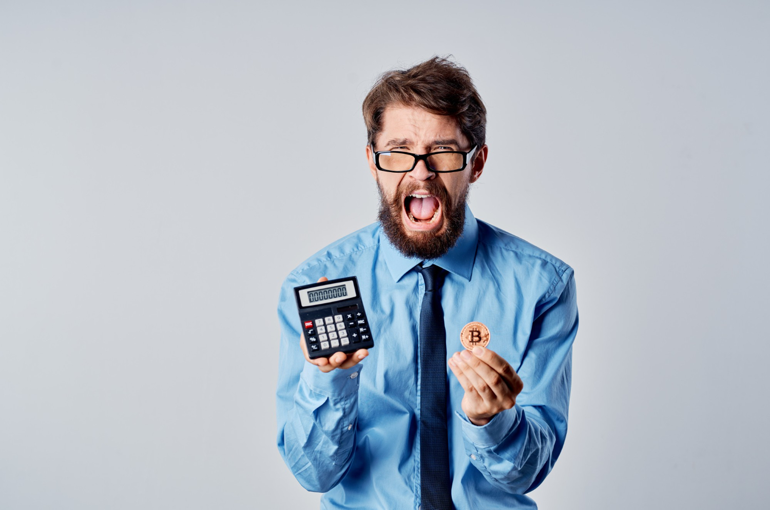 Homem de negócios desesperado segurando Bitcoin e calculadora imposto com criptomoedas