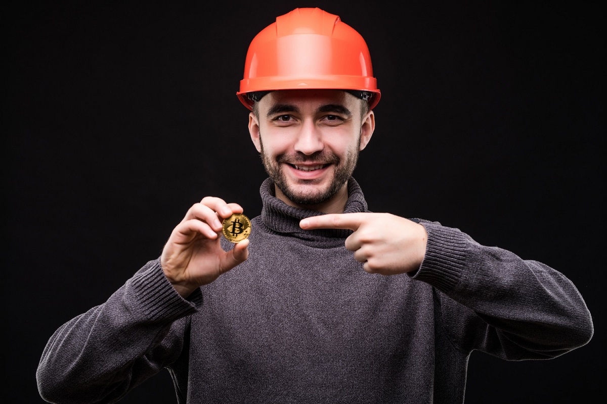 Minerador de Bitcoin apontando dedo para moeda digital