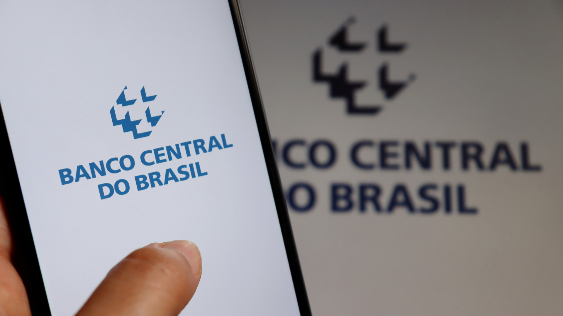 Aplicativo do Banco Central do Brasil em frente a logo da autarquia