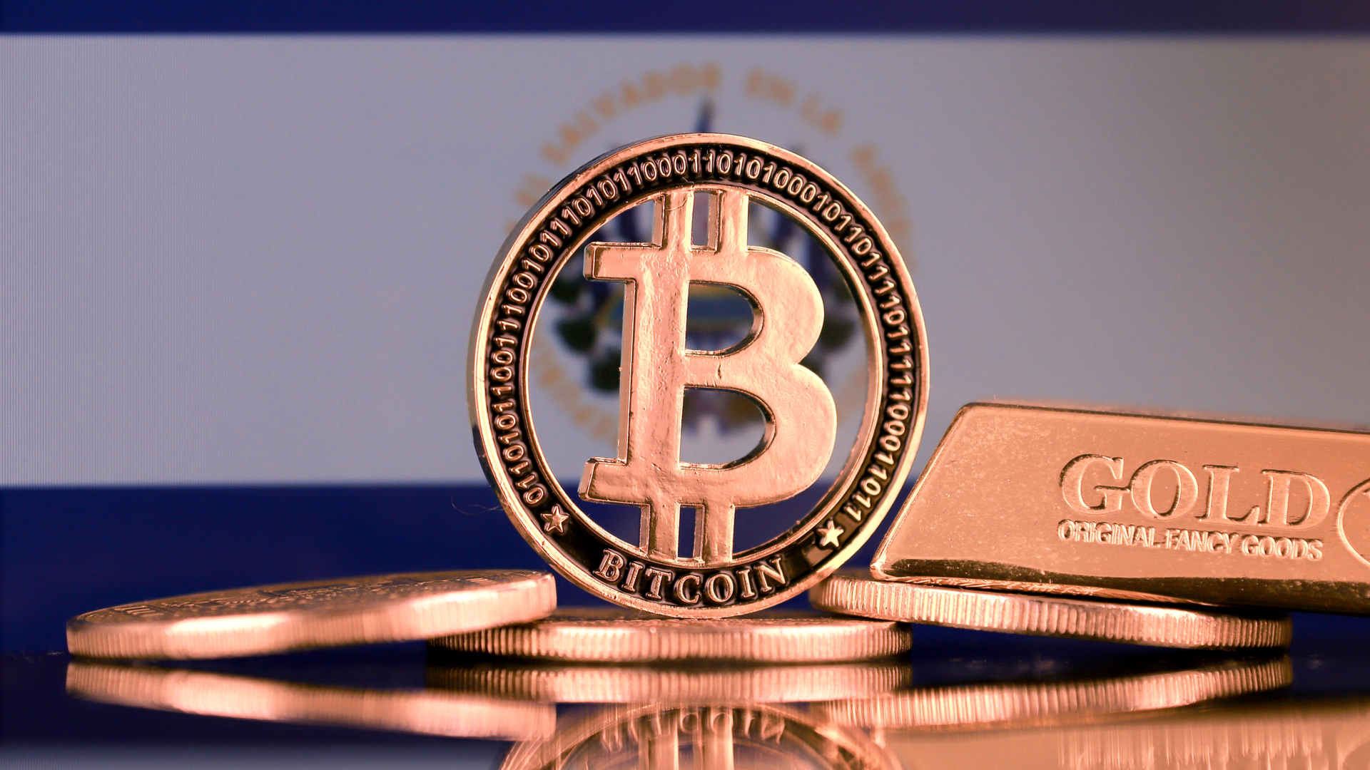 Bandeira de El Salvador ao fundo do Bitcoin e ouro