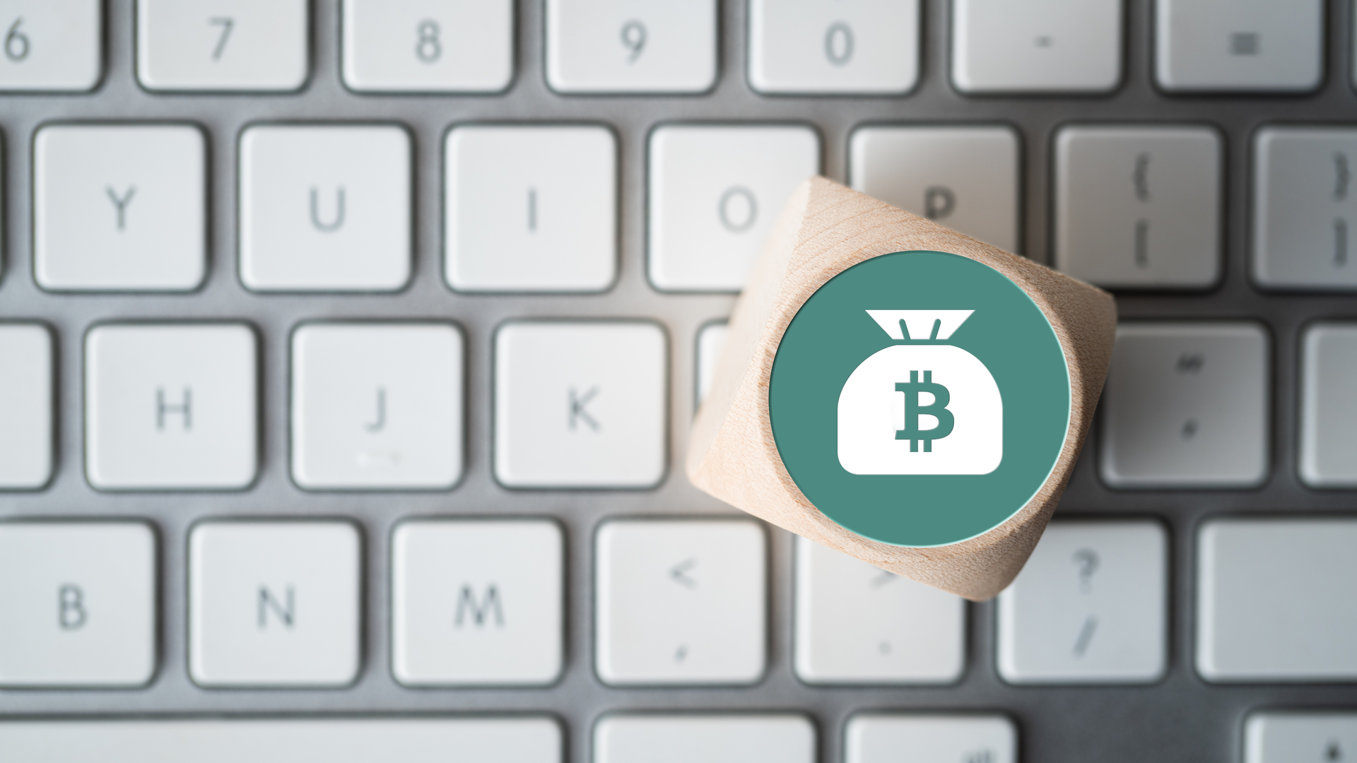 Cubo com símbolo de bitcoin em um teclado de computador