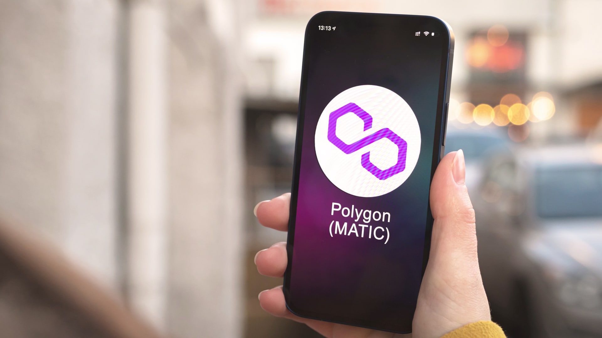 Mão segurando celular com aplicativo da Polygon MATIC