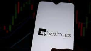 XP Investimentos e gráficos ao fundo