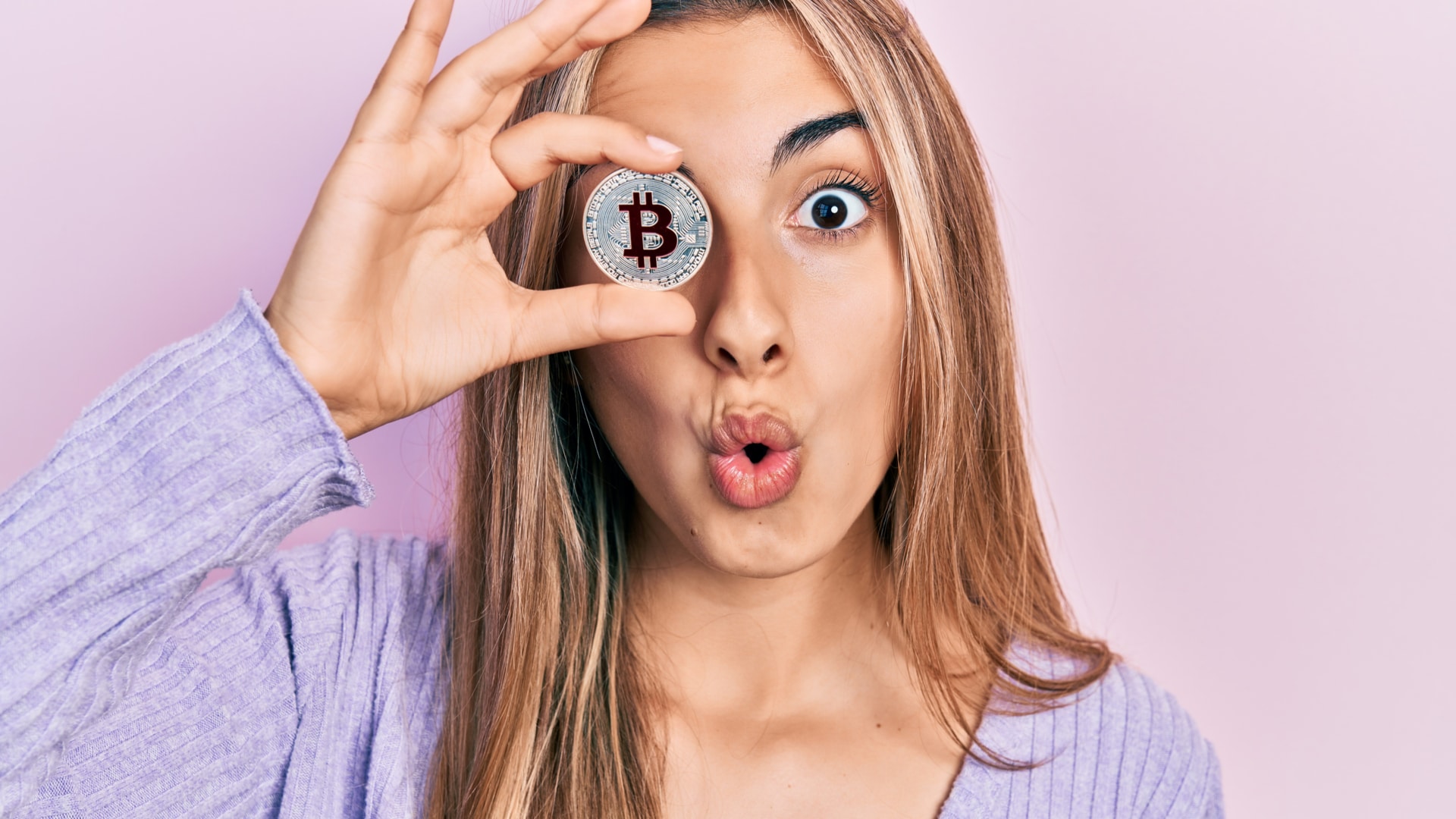 Mulher segurando bitcoin com medo