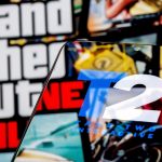 Símbolo da Take-Two em celular, com GTA ao fundo