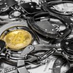 Moeda Bitcoin entre algemas e acima de notas de dinheiro