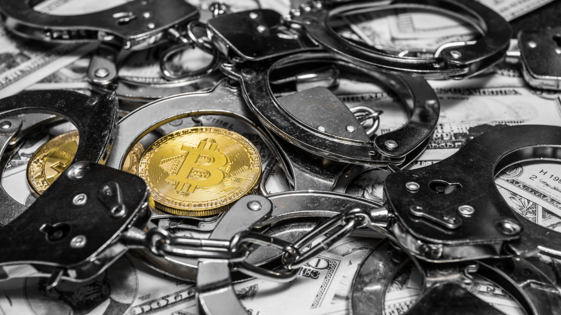 Moeda Bitcoin entre algemas e acima de notas de dinheiro