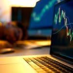 Usuário de Bitcoin dormindo em frente ao computador com gráfico subindo.