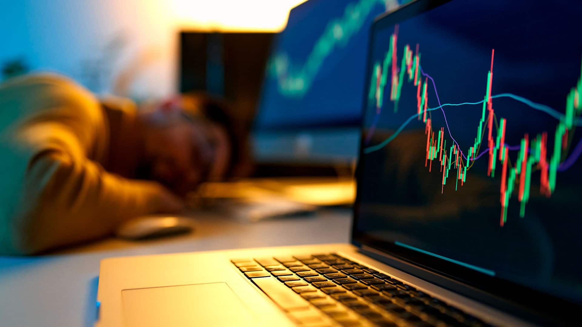 Usuário de Bitcoin dormindo em frente ao computador com gráfico subindo.