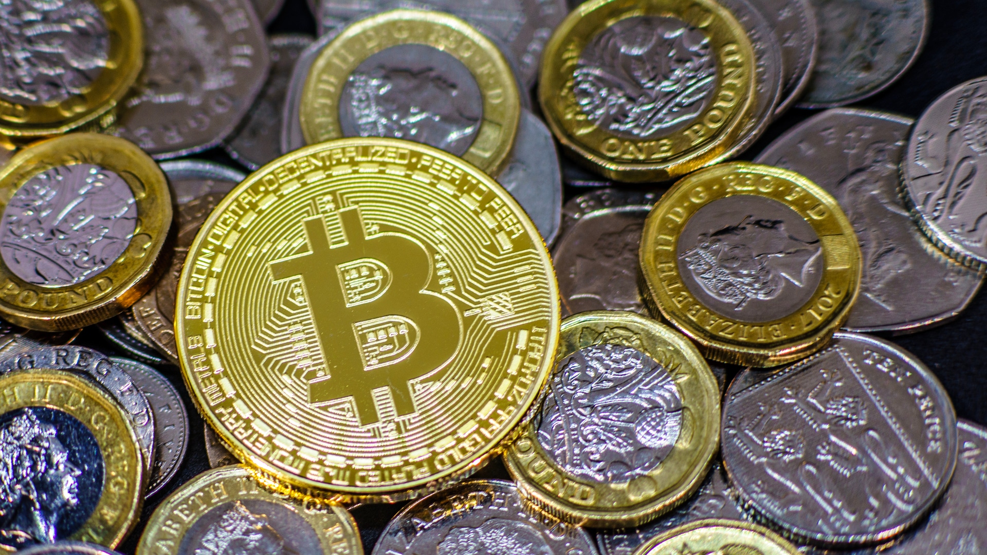 Moedas de Bitcoin e Libra Esterlina.
