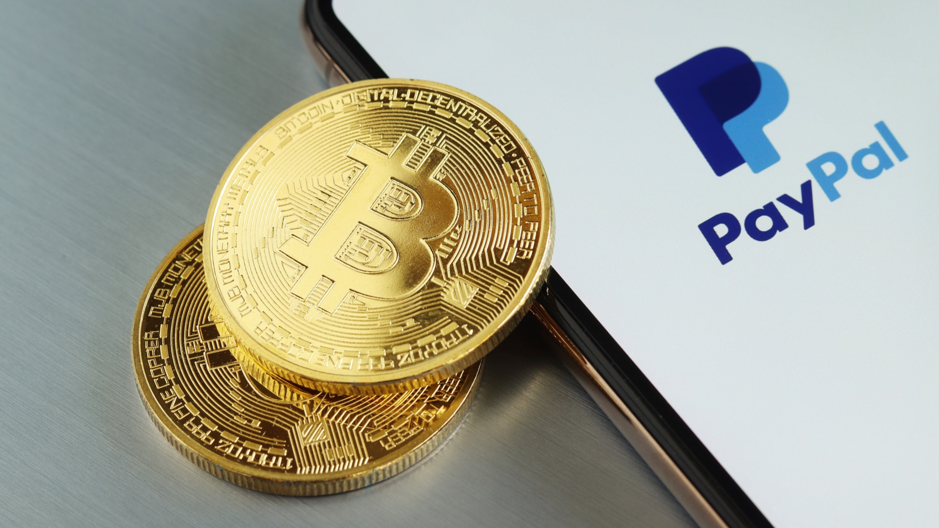 Moedas de Bitcoin e aplicativo do PayPal.