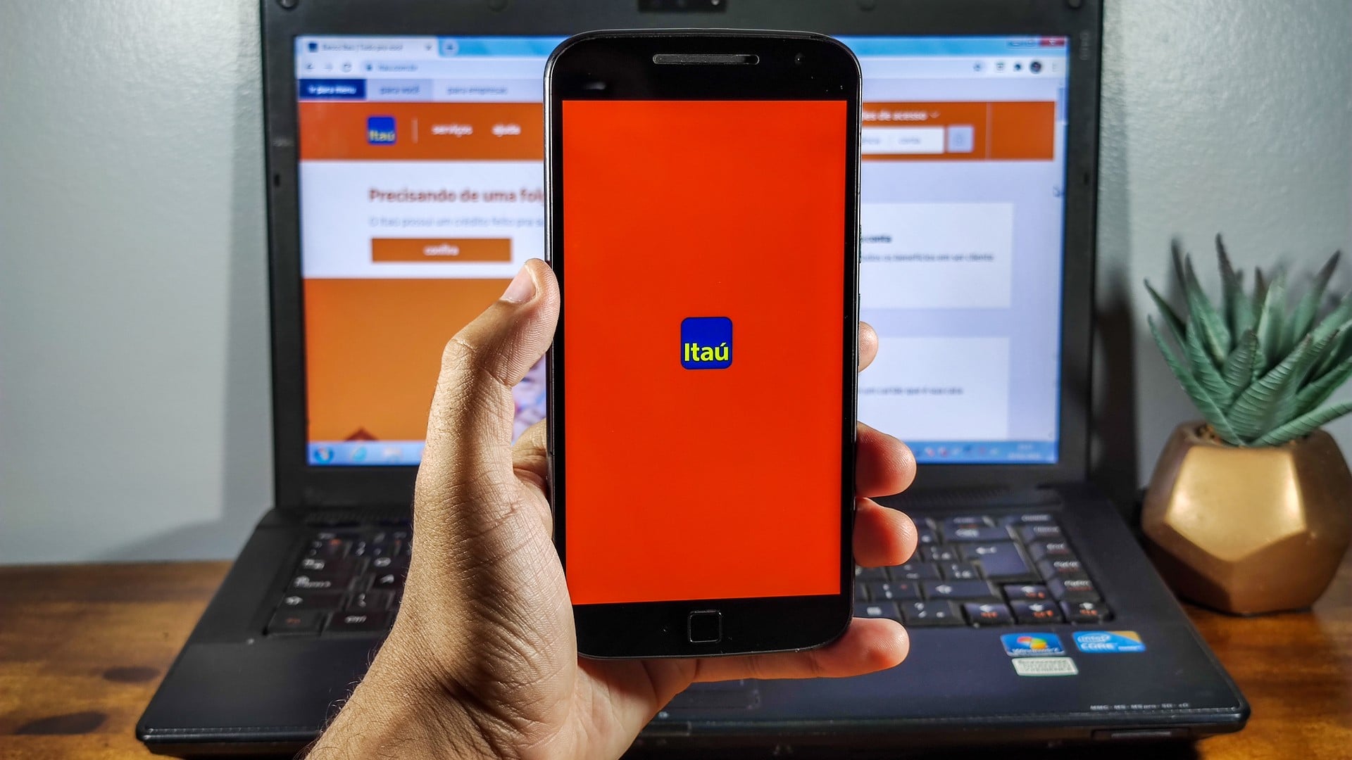 Mão segurando celular com aplicativo do Itaú