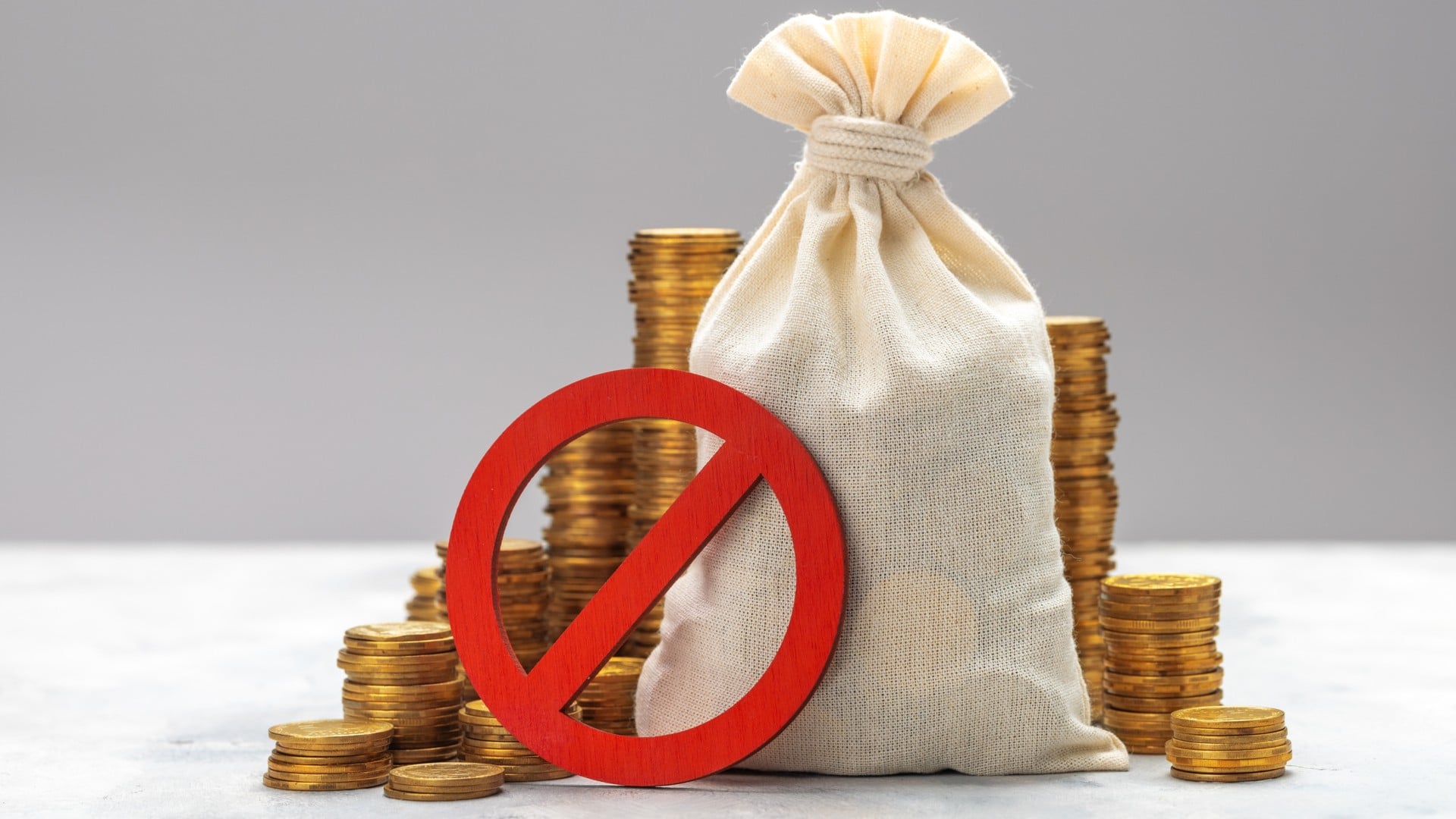 Símbolo de proibido com sacola de moedas ao fundo