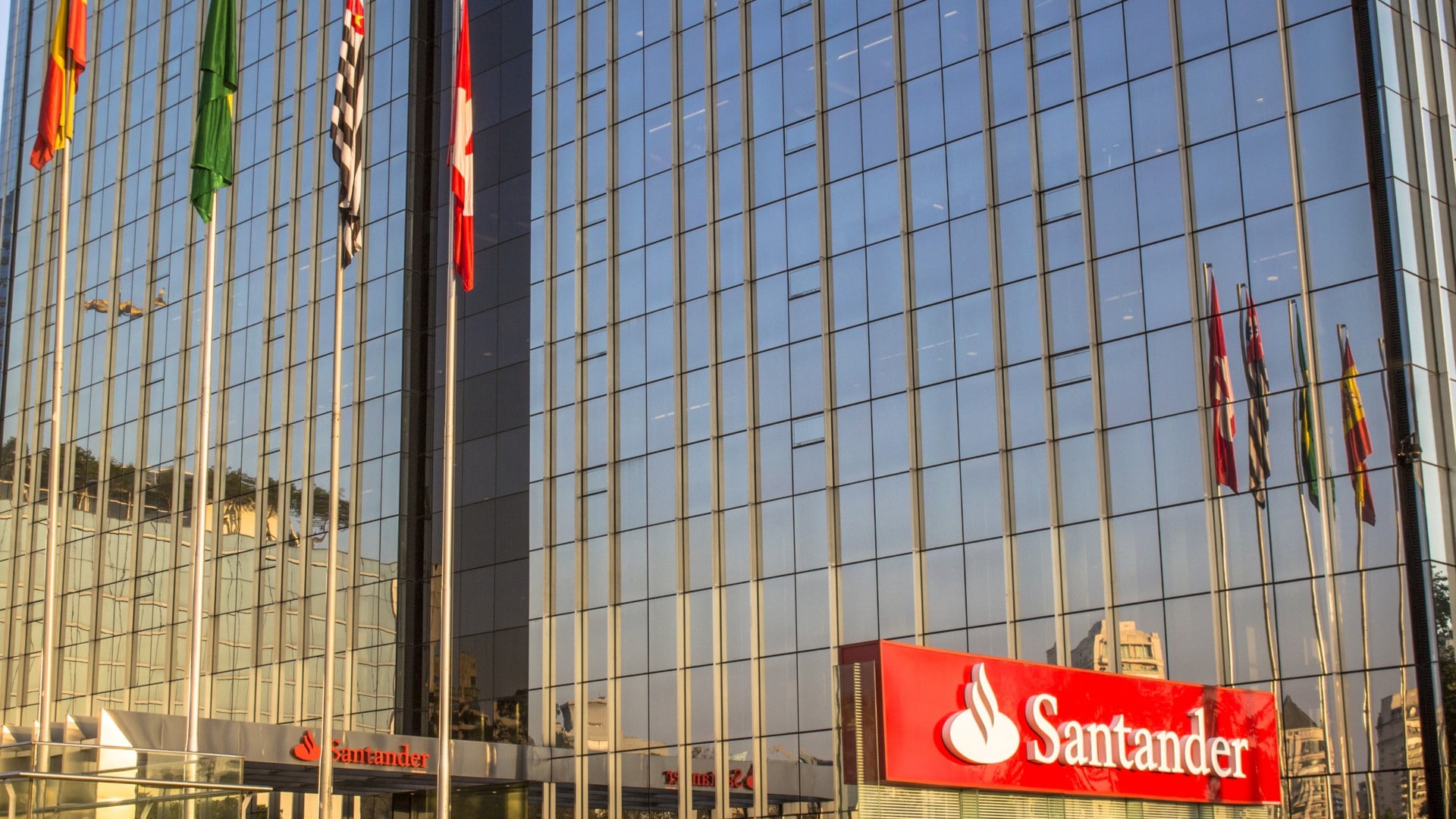 Símbolo do Santander próximo de bandeira do Brasil e outros países