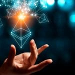 Mão segurando logotipo holográfico do Ethereum.
