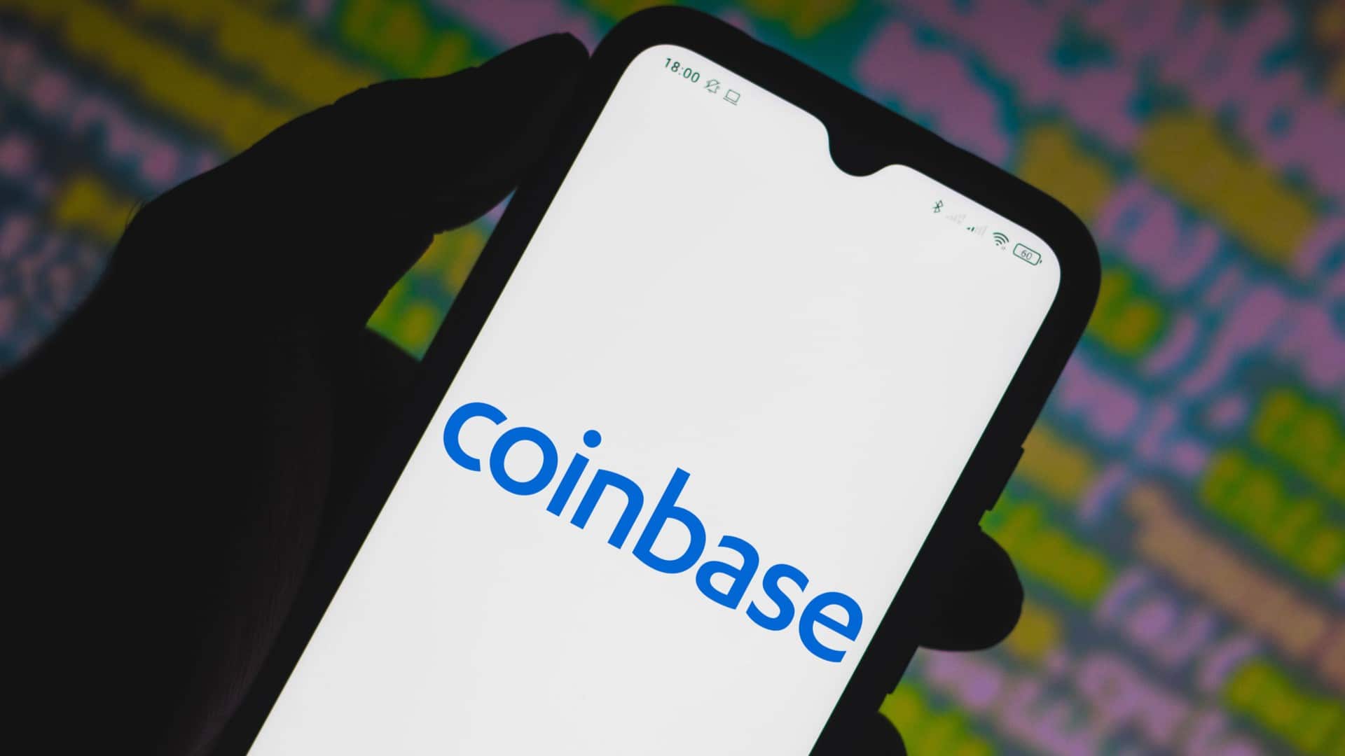 Aplicativo da Coinbase com códigos ao fundo