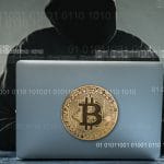 Hacker com computador com imagem do bitcoin