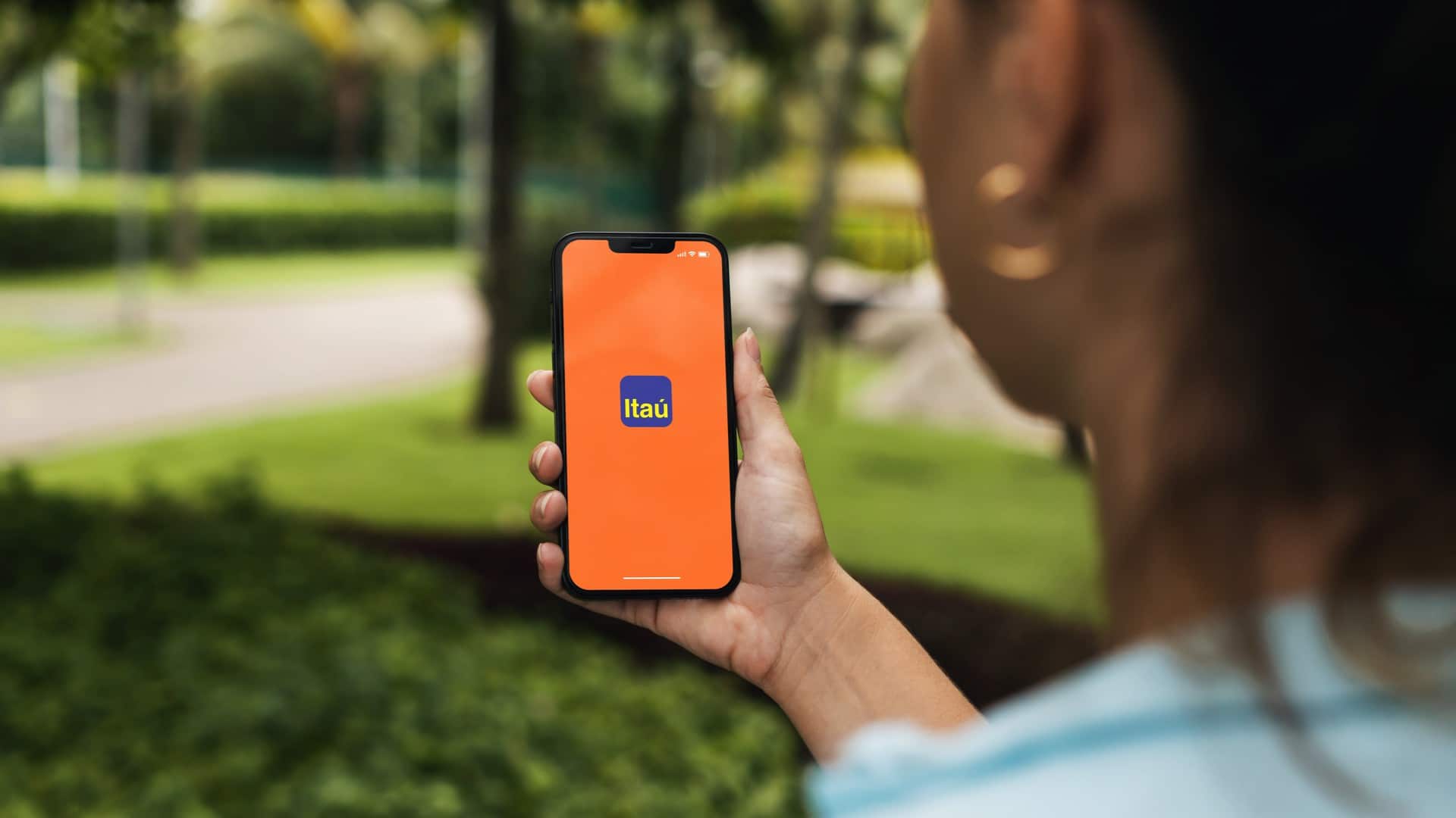 Mulher usando aplicativo de celular do Itaú