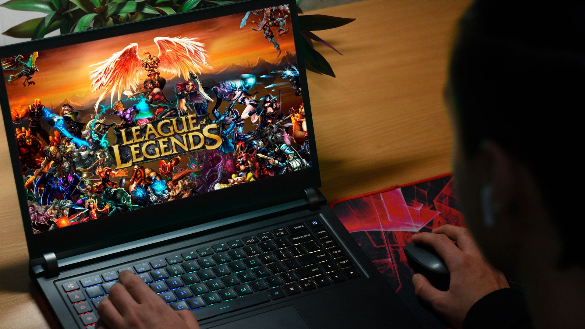 Jovem jogando League of Legends em notebook.