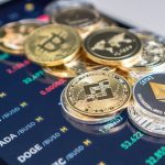 Diversas criptomoedas sobre celular em app de uma exchange.