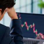 Investidor de Bitcoin acompanhando preço em queda.
