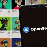 Celular com logotipo da OpenSea sobre catalogo de NFTs.