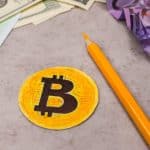 Bitcoin falso colorido, próximo de notas amassadas