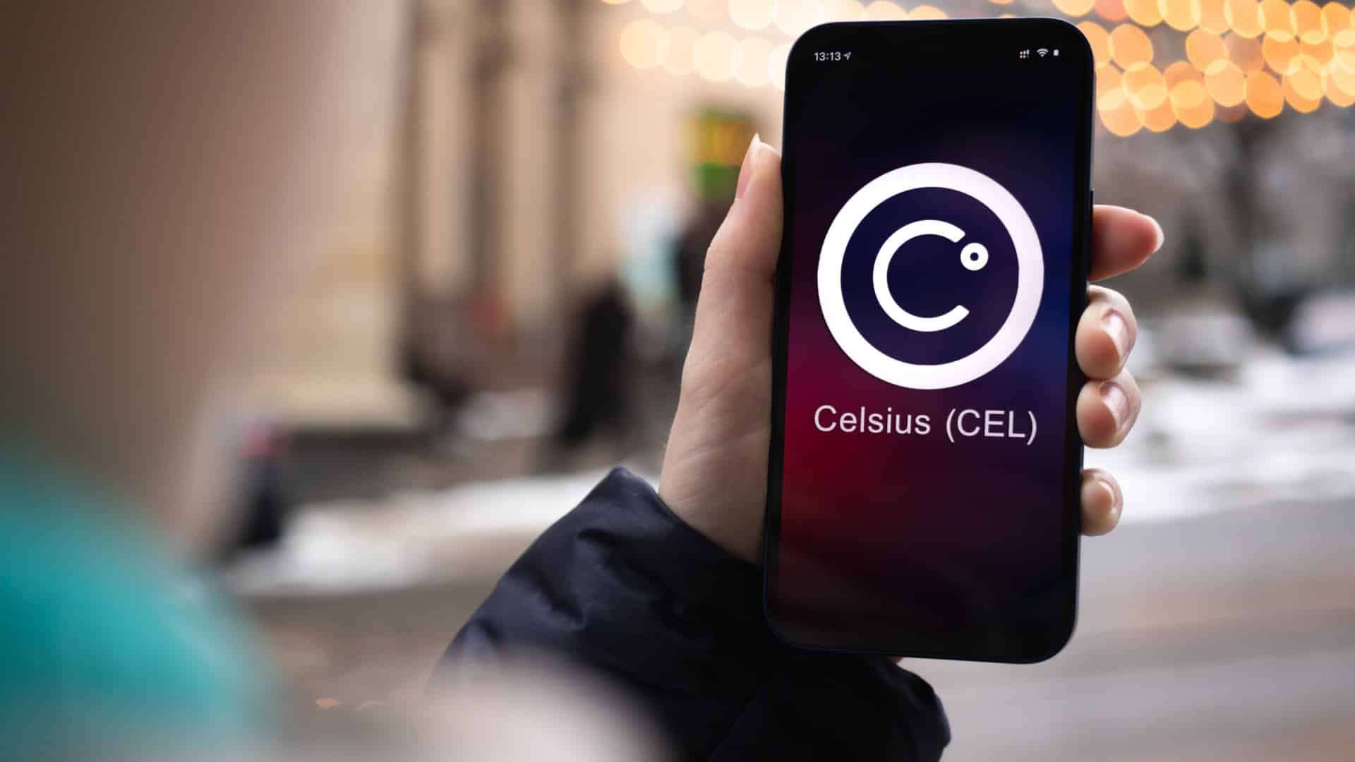 Mão segurando celular com imagem de criptomoeda de corretora Celsius