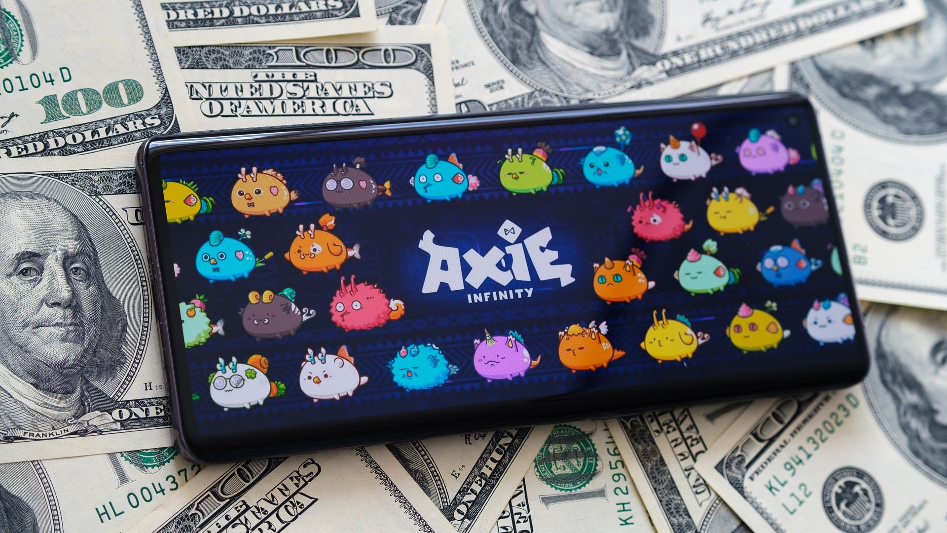 Axie Infinity em smartphone sobre notas de dólar.