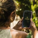 Brasileira usando aplicativo da Binance no celular.