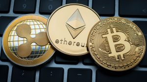 Criptomoedas Ripple, Ethereum e Bitcoin sobre teclado.