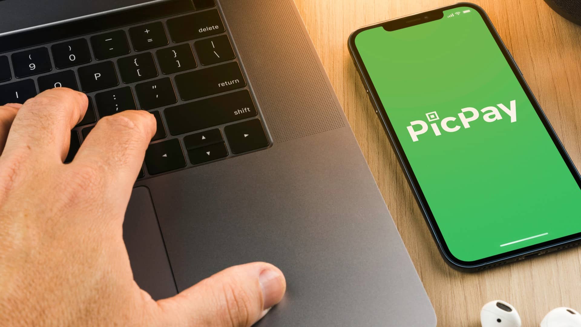 Programador ao lado de aplicativo do PicPay